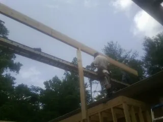 Carpenter setting a ridge beam over a new addition frame — Ice Dam Removal by Roofing Brothers in Colts Neck