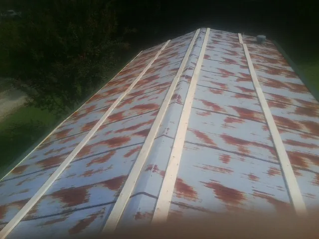 Rusted metal roof panels with new wood purlins before replacement — Storm Damage Roof Repair in Colts Neck by Roofing Brothers