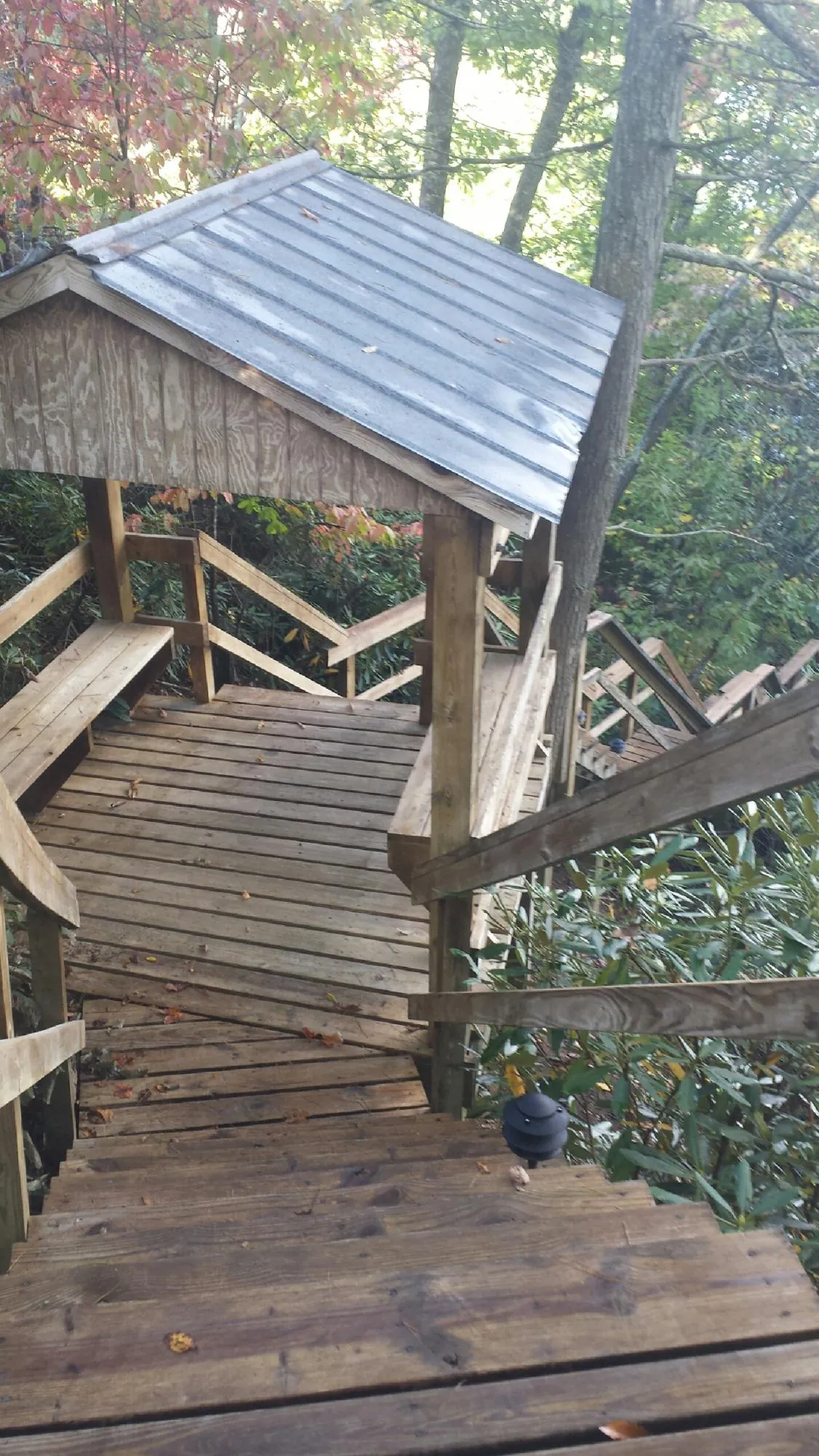 Metal roofed shelter over wooden steps on a wooded walkway — Skylight Repair & Installation work by our crew in Colts Neck