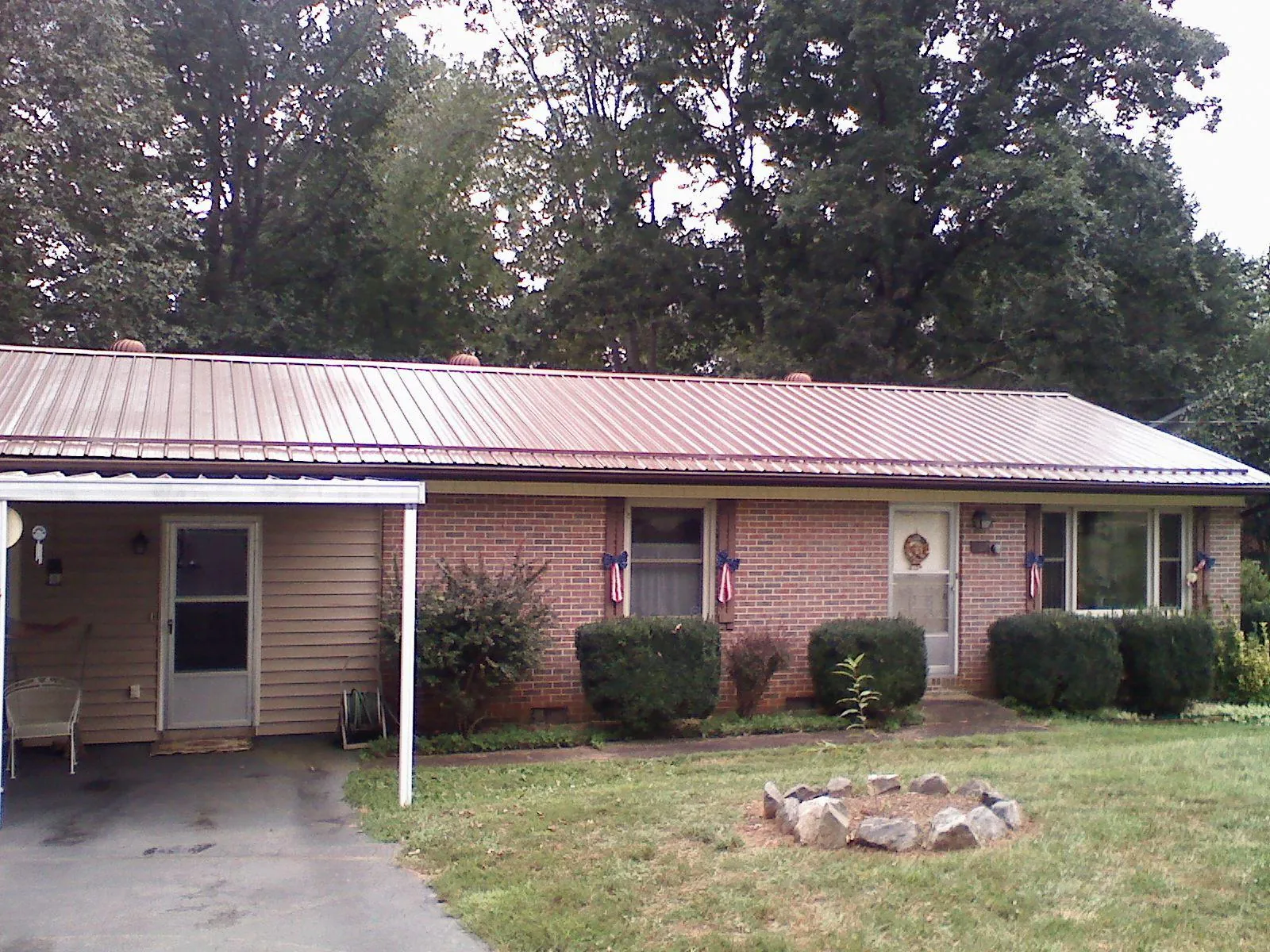Bronze metal roof and carport on a brick ranch home — Roof Repair work by our crew in Colts Neck